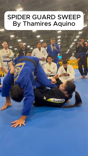 SPIDER GUARD SWEEP - Thamires Aquino — Spider Guard to X-Guard Sweep (Jiu Jitsu Con 2025) Thamires shows exactly why world-class guard work is all about angles, timing, and controlled off-balancing. From spider guard, she locks a strong sleeve grip and threads her leg under the near leg, lifting the base just enough to force a reaction. When the opponent tries to posture or step out, she transitions seamlessly into X-guard, connects her hooks, and tilts the base line—sending them over with a cle