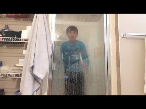 Kid takes shower with clothes on.