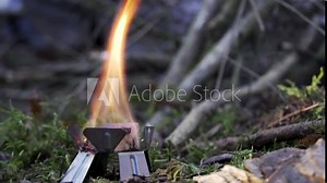 Hexamine fuel tablet burning in the woods in slow motion. Camping in wilderness concept.