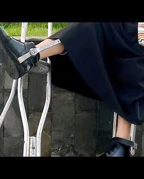 The beautiful woman with polio walks on crutches and an orthosis #polio