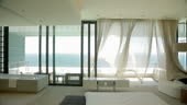 Wind blowing curtain in luxury master bedroom overlooking ocean. MS,...