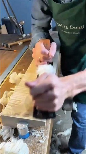 Hand plane smoothing a light wood surface to create fine decorative ridges