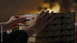 The pizza chef manager collects orders for delivery to customers. A stack of cardboard boxes. A food delivery manager prepares pizza boxes for delivery. Food delivery, sustainable modern business