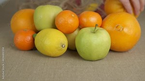 Healthy life and eco friend. A woman puts fresh apples and oranges on the table from the eco friendly bag.