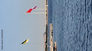 the highest and largest flags in the world, the imperial flag of white-black-yellow, the red flag of the USSR at sunny day, and the flag of Russia, a new chapel in the port of Hercules,