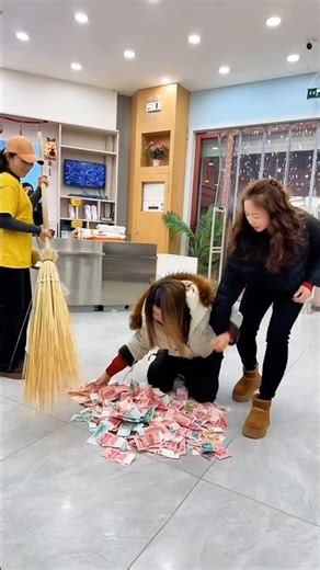 The girl stuffs the fallen money into her jacket