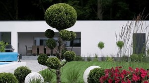 Front yard, landscape design With multicolored shrubs intersecting with bright green lawns Behind the house is a modern, garden care service, green grass with a beautiful yard for the background.