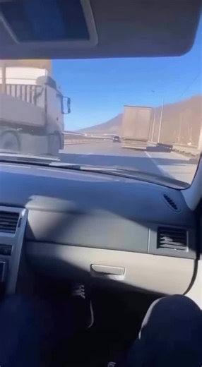 Ева 🧴 Уход за кожей лица и тела on Instagram: "A tense moment on the highway! During a drive on a sunny road, where dry hills frame a multi-lane highway, a passenger is filming with a smartphone. Suddenly, a huge truck appears nearby, traveling extremely close in the right lane. The camera suddenly shakes from a sharp jolt – the screech of metal is heard, and the side of the trailer rushes past inches from the car. After a second of panic, the camera jerks sharply to the left to show the driver