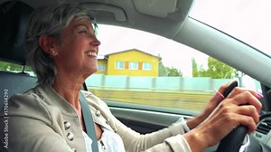 Middle aged woman drives a car, listens music and dances Stock Video