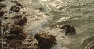 The clear azure waves ripple amidst the rocks.