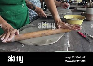 A happy couple makes ceramic plates in a workshop.