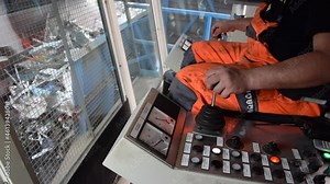 An employee loading scrap metal loading in to a shredder.