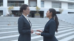 Free stock video - Side view of happy female business partners meeting outside, shaking hands, smiling and talking together