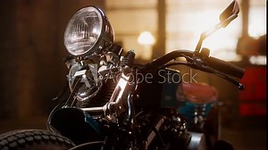 Close Up Details of a Custom Bobber Motorbike Standing in an Authentic Creative Workshop. Chromed Motorbike Headlight, Handle Bars and Shock Absorbers with Springs.