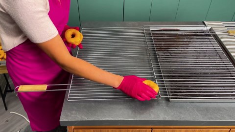 Perfectly glazed chocolate donuts on a grill tray