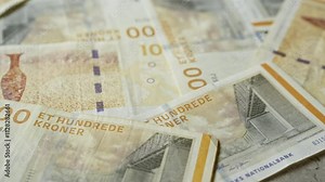 Denmark kroner banknotes scattered across a surface, showcasing various details and designs of the danish currency prominently.