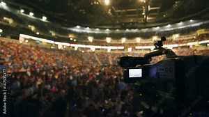 Shot of Video Camera taking video of crowd at packed venue before show starts