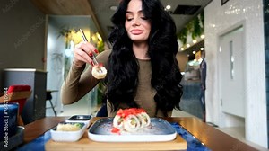 A beautiful young girl eating sushi in a restaurant. Lunch at the sushi bar.