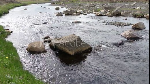 Fantastic landscape with flowing rivers and streams with rocks and grass in Iceland.