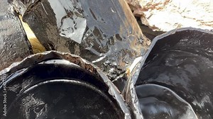 buckets and various containers with hardened bitumen