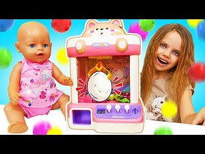 Maya and Lina are trying to get a toy out of the claw machine and are playing with their mom.