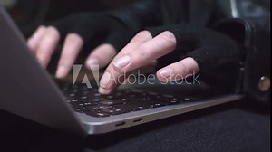 Hands in gloves typing and swiping on a laptop, then closing it