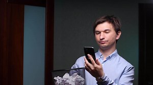 Man throws smartphone into trash bin