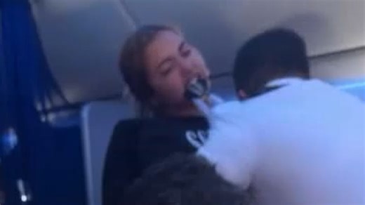 Shocking moment airline passenger bites flight attendant in mid-air meltdown