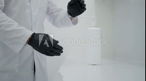 Medical worker in laboratory uses disinfectant while practicing hygiene.