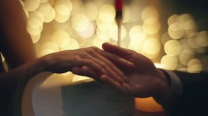 clip-3509606683-evening-couple-touching-hands-blurred-background-closeup
