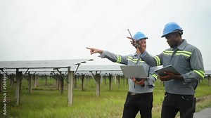 electrical engineer and workman walking between solar panels on ecological field station,alternative energy,solar panel,controller box,green renewable energy,sustainability development energy concept