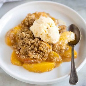 This PEACH CRISP is EASY and unbelievably delicious. Fresh peaches in a simple syrup, topped with an amazing cinnamon oat topping and baked. Best served warm, with vanilla ice cream! 🤤 🍑https://tastesbetterfromscratch.com/peach-crisp/ | Tastes Better From Scratch
