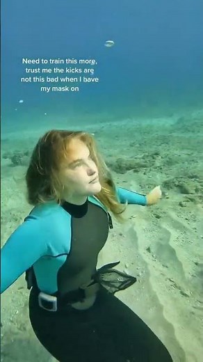 female freediver underwater with no mask on and no fins