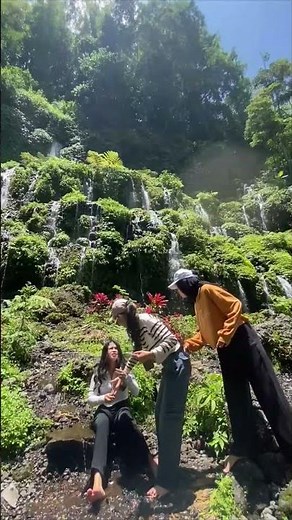 Woman Slips and Falls on Mossy Waterfall Rocks