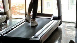 Woman walking on a treadmill for exercising in slow motion in a gym. fitness and healthy lifestyle concept.
