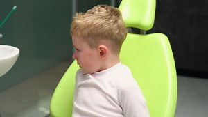Scared boy crying at reception at dentist in dental chair