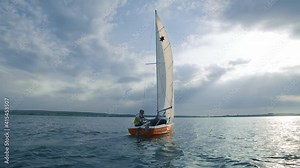 Couple of professional sailors traveling on boat in beautiful seascape outside. Sailing across a large peaceful lake. Concept for travel, sea.