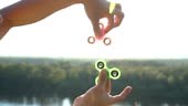Hand spinner rotating on child's hand, slow motion