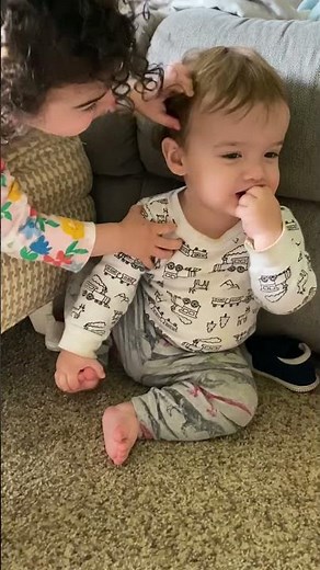 Sister tickling baby brother