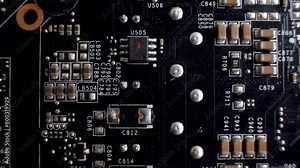 A close-up of the rear side of a graphics card reveals the PCB, a slender platform accommodating various chips and electronic elements. Connector interface.