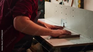 Woodworking expert wears protection gear, inserting plank in spindle moulder next to coworker. CNC machinist uses safety glasses while cutting lumber with wood shaper helped by colleague, camera A