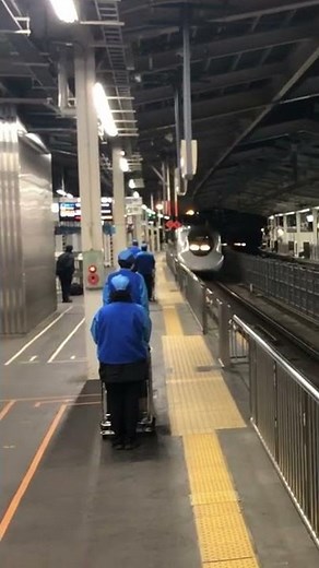 新幹線に一礼する清掃員さん