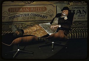 Clown from Barnum & Bailey circus reclining on Eames lounge chair