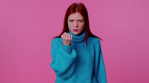Aggressive angry girl trying to fight at camera, shaking fist, boxing with expression, punishment