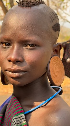 The Surma (or Suri) women of Ethiopia are known for their large lip plates and also for wearing plates or "ornaments" in their ears. These plates, usually made of clay or wood, are placed in the earlobes, which are progressively stretched from a young age. They represent beauty, status, and maturity within their culture, and the larger the plate, the greater the social recognition. It is both an aesthetic and cultural symbol, passed down from generation to generation. #inspirationofafrica | Quim