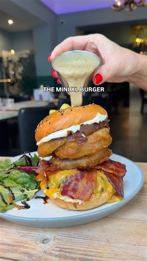 Head chef wants to know if you’d order this burger stack before we stick it on the menu? 👀 comes with beef patty, cheese, haggis fritter, bacon, onion rings and peppercorn sauce. Bosh. | Mini Grill Scottish Steakhouse