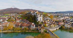 Flight over the Aare river in Aarburg city, Switzerland. autumn Aerial drone shot rotating around the church and fortress of the town of Aarburg in Switzerland. Aerial view of landmarks Aarburg city.