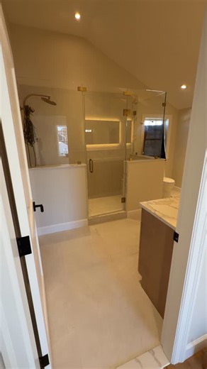 Davie Mac Tile on Instagram: "This bathroom looks calm on purpose. That only happens when the layout is planned before the first tile goes up. The large-format wall tile isn’t just a style choice. Fewer grout lines means less visual noise and easier maintenance long term. The bench and niche were built first, waterproofed as one system, then tiled so nothing relies on caulk to survive. The glass lines up with tile joints because the tile layout was set with the glass shop in mind from day one. T
