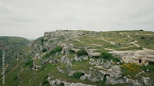 Drone shot of Murgia National Park with ruined stone buildings and caves on a hill