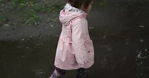 Girl walking in puddle water